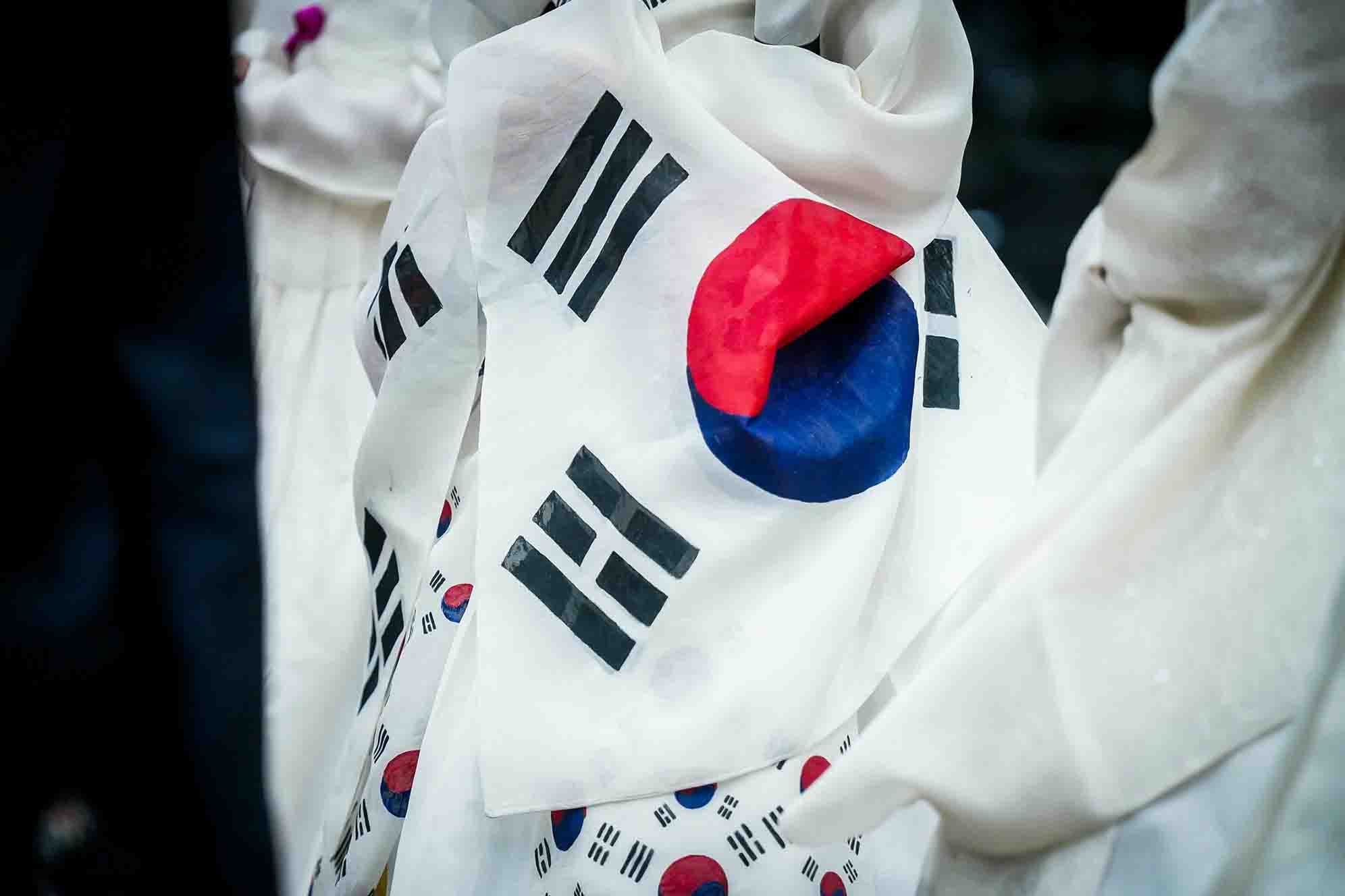 South Korea flag held by traditional dress